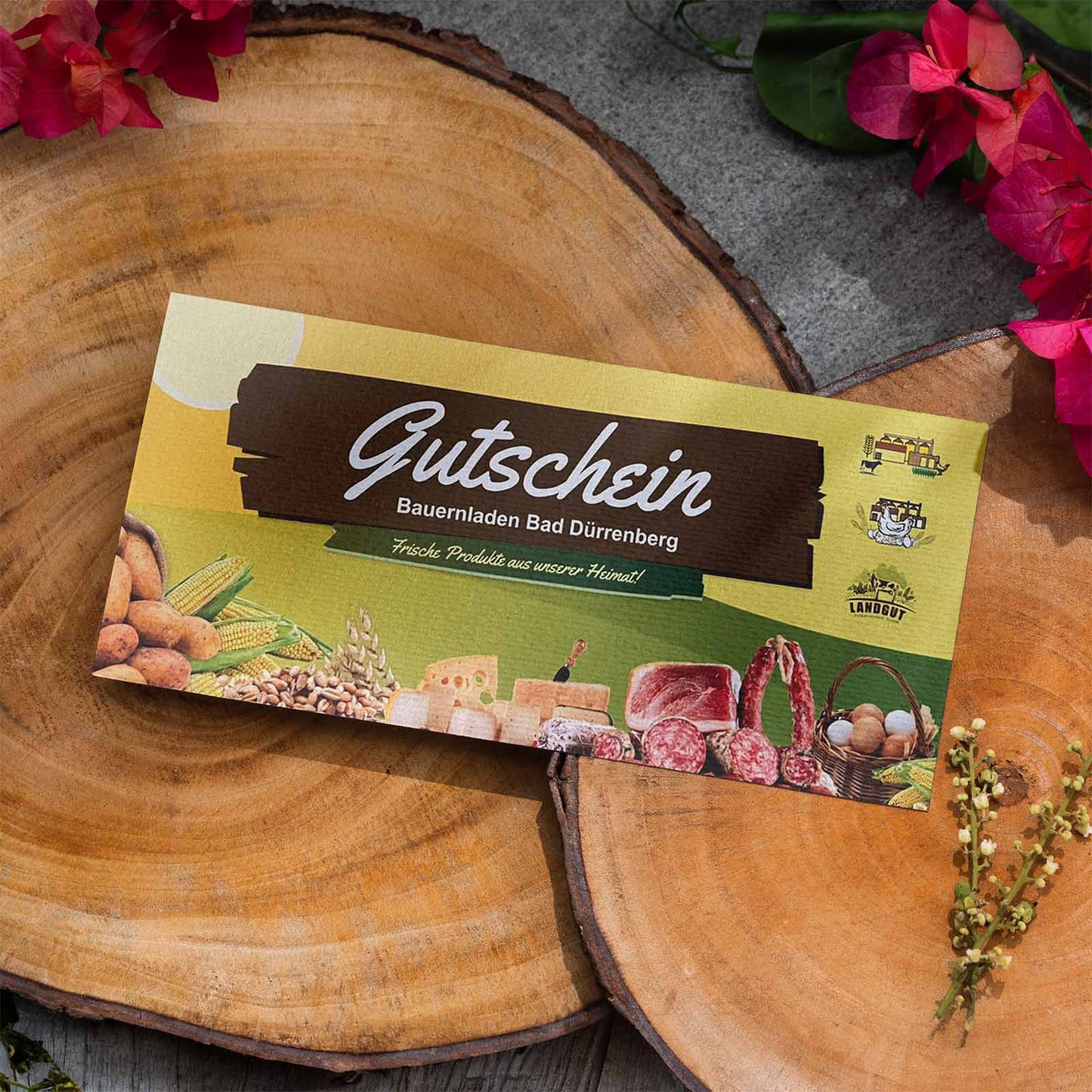 Abbildung eines Gutscheines, auf Baumstümpfen mit Blumen.