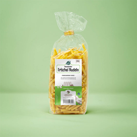 Frontalansicht von Hausmacher Frischei Makarroni kurz 250 Gramm in einer Plastiktüte mit Etikett.