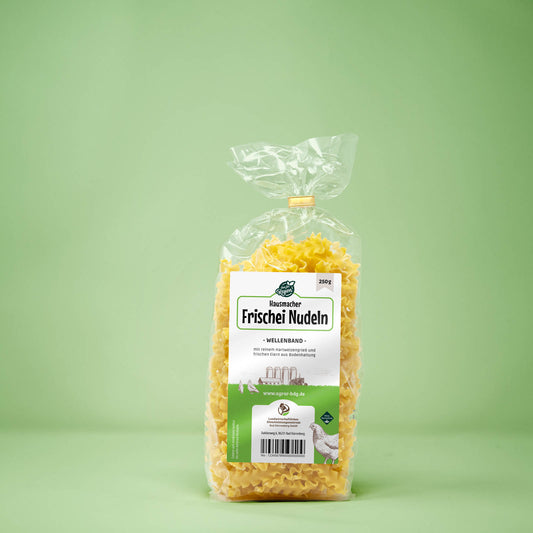 Frontalansicht von Hausmacher Frischei Wellenband Nudeln 250 Gramm in einer Plastiktüte mit Etikett.