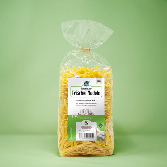 Frontalansicht von Hausmacher Frischei Bandnudeln 4 mm 500 Gramm in einer Plastiktüte mit Etikett.