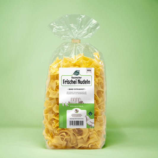 Frontalansicht von Hausmacher Frischei Bandnudeln extrabreit 500 Gramm in einer Plastiktüte mit Etikett.