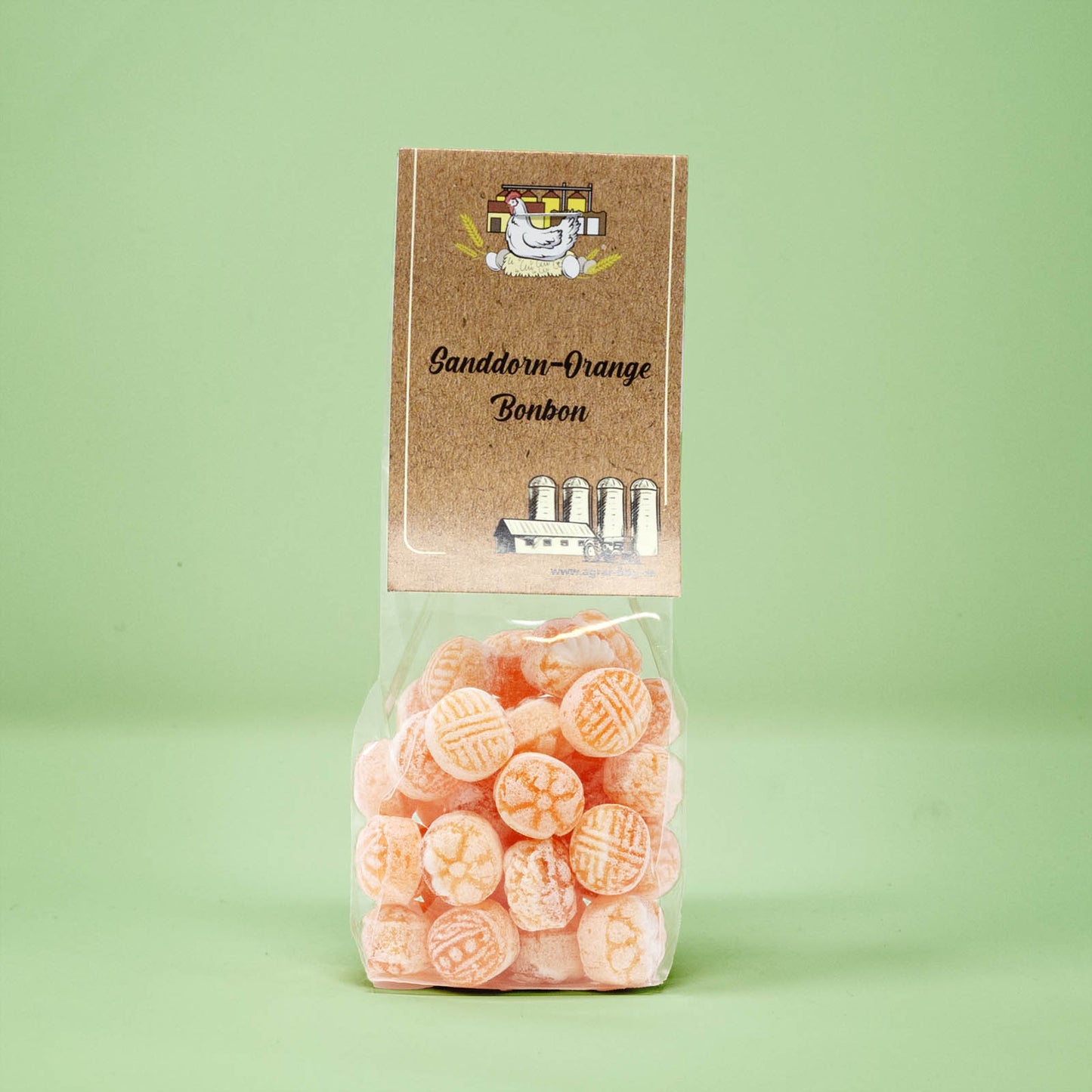 Frontalansicht von Sanddorn-Orange Bonbons in einer transparenten Plastiktüte mit einem Pappetikett.