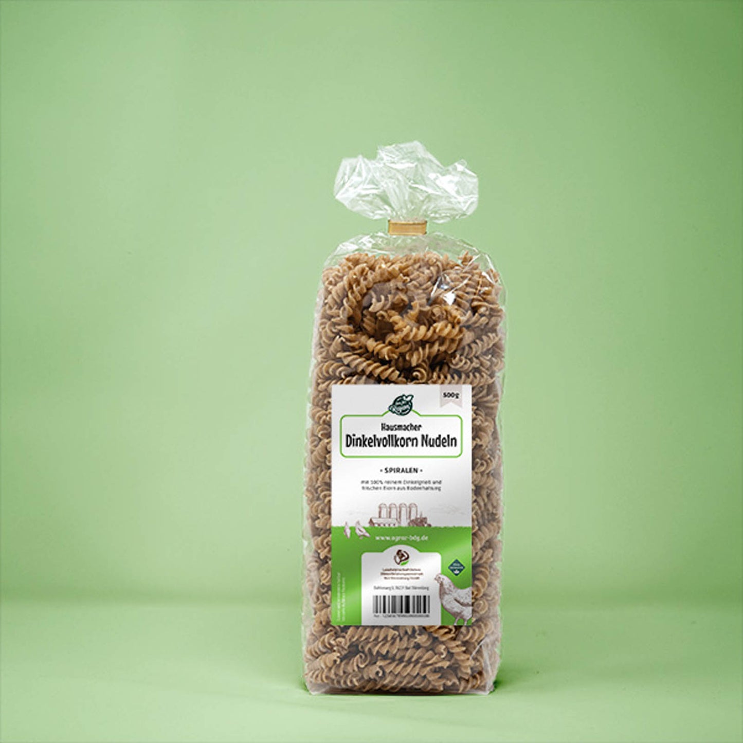 Frontalansicht von Hausmacher Dinkelvollkorn Spiralen Nudeln 500 Gramm in einer Plastiktüte mit Etikett.