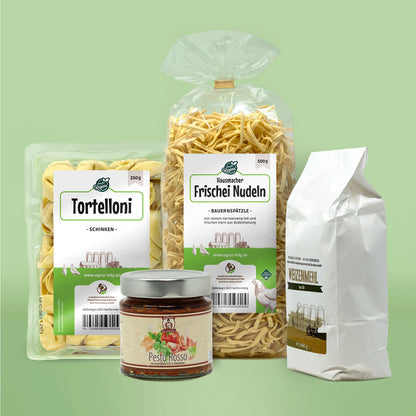 Inhalt des Genuspakets Kuechenfreude. Von links nach rechts: Tortelloni, Pesto RossoBauernspaetzle und Weizenmehl.