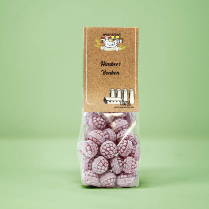 Frontalansicht von Himbeer Bonbons in einer transparenten Plastiktüte mit einem Pappetikett.