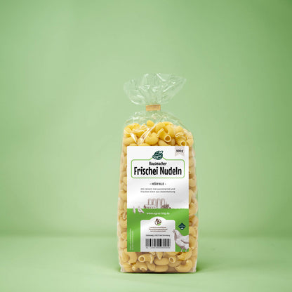 Frontalansicht von Hausmacher Frischei Hoernle Nudeln 500 Gramm in einer Plastiktüte mit Etikett.