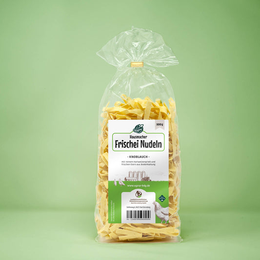Frontalansicht von Hausmacher Frischei Knoblauch Nudeln 500 Gramm in einer Plastiktüte mit Etikett.