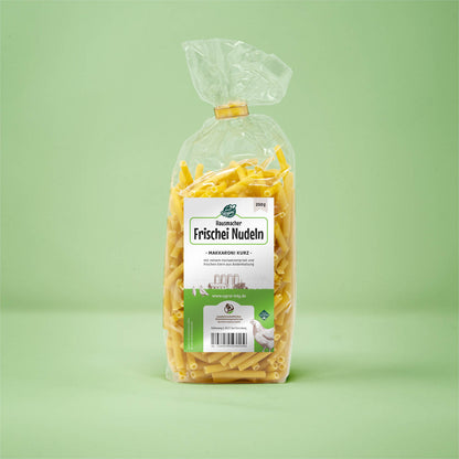 Frontalansicht von Hausmacher Frischei Makarroni kurz 250 Gramm in einer Plastiktüte mit Etikett.