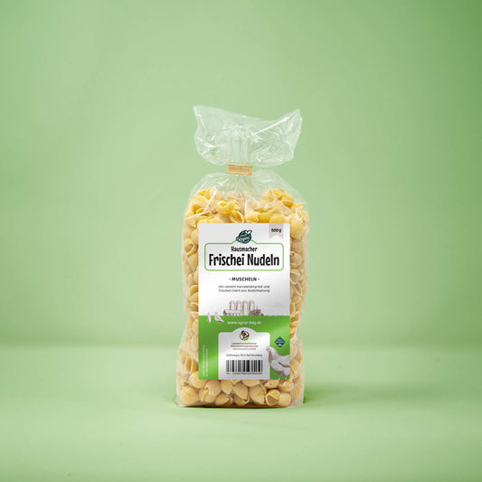 Frontalansicht von Hausmacher Frischei Muschel Nudeln 500 Gramm in einer Plastiktüte mit Etikett.