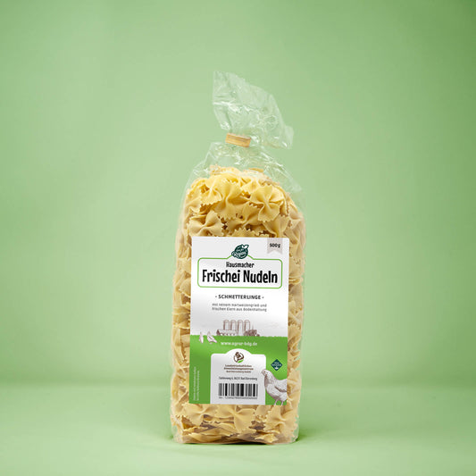 Frontalansicht von Hausmacher Frischei Schmetterling Nudeln 500 Gramm in einer Plastiktüte mit Etikett.