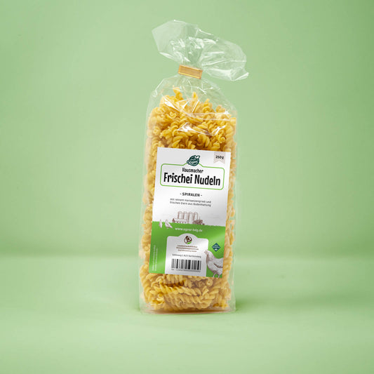 Frontalansicht von Hausmacher Frischei Spiralen Nudeln 250 Gramm in einer Plastiktüte mit Etikett.