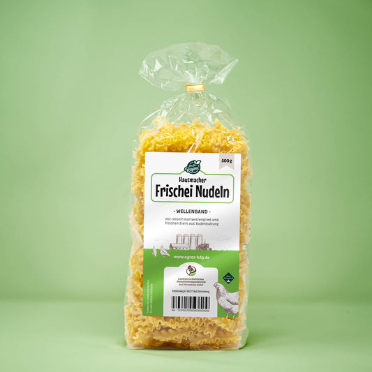 Frontalansicht von Hausmacher Frischei Wellenband Nudeln 500 Gram in einer Plastiktüte mit Etikett.